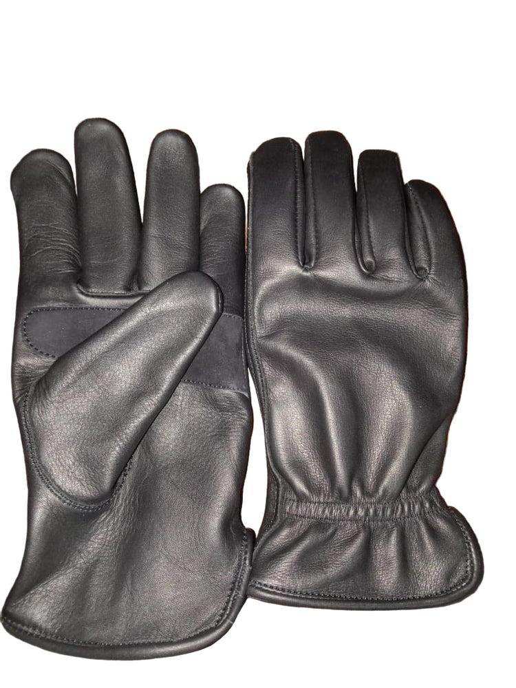 Pair of black leather gloves on a wooden surface