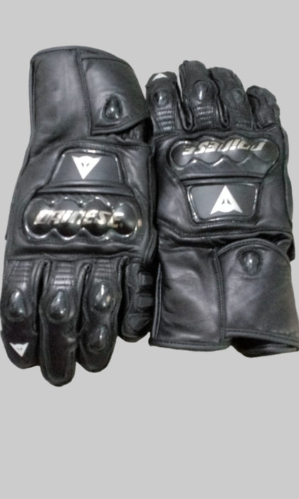 Pair of black motorcycle gloves with brand logos on a checkered background